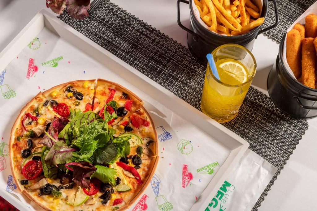 a pizza in a box with french fries and a drink at Megasaray Club Belek in Belek