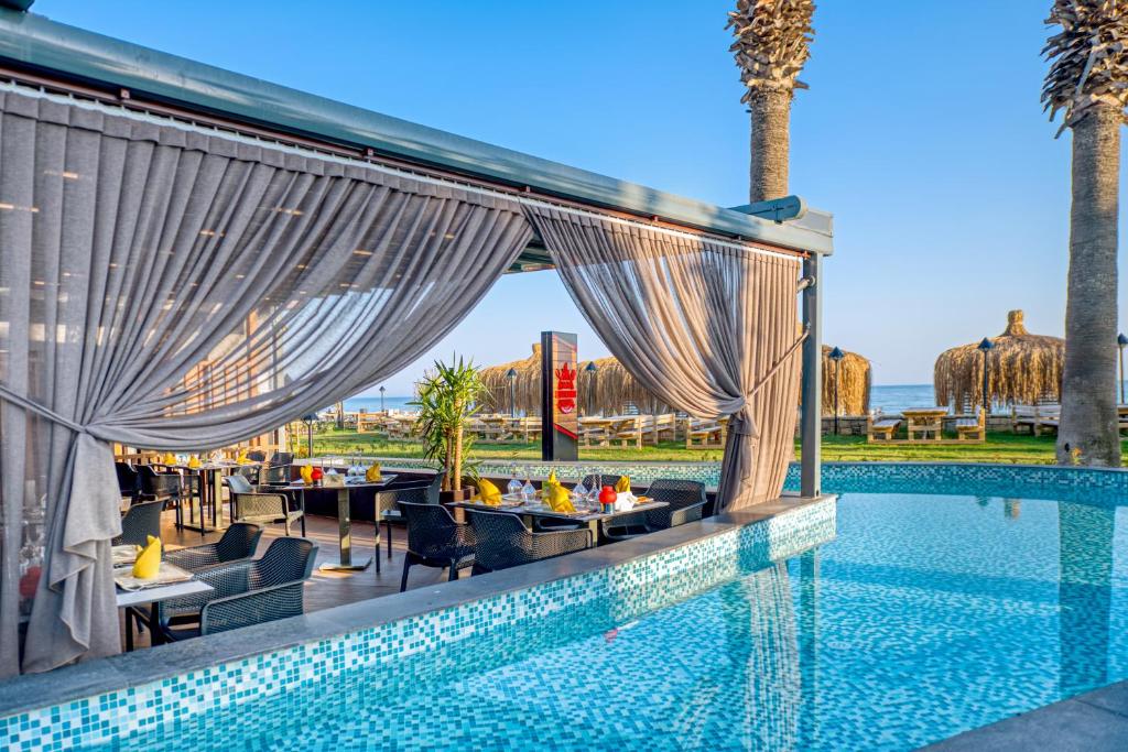 a swimming pool with tables and chairs next to a resort at Megasaray Club Belek in Belek