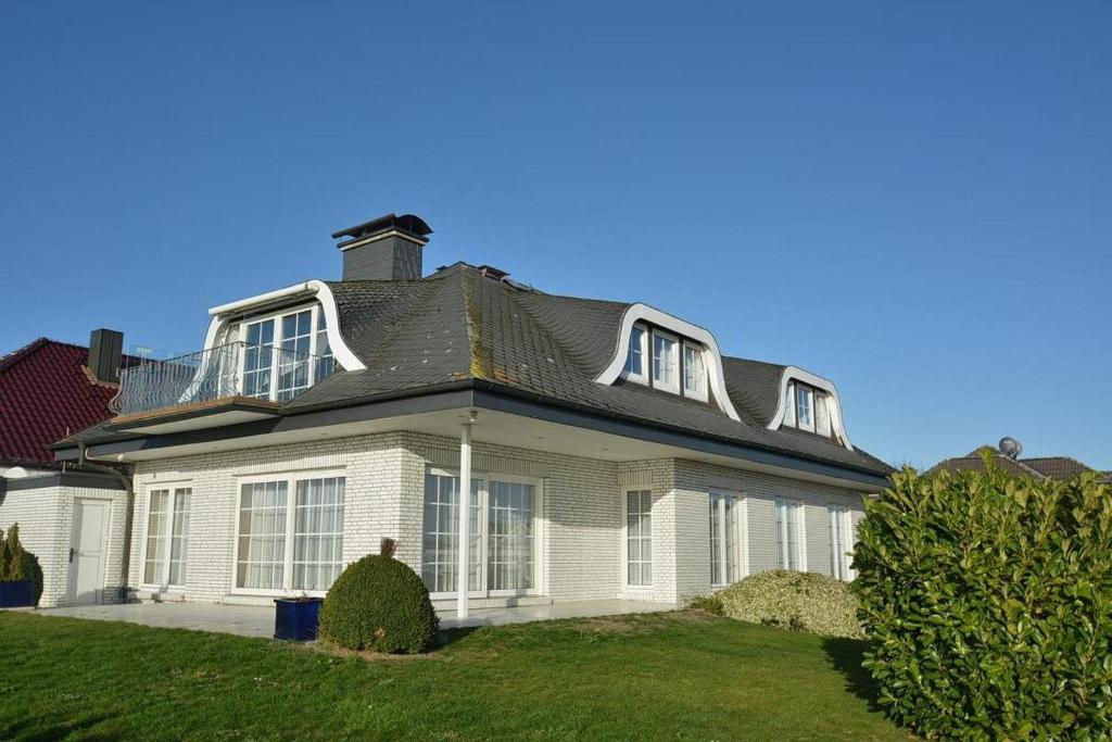 a white house with a black roof at Hafenblick Whg 15 in Grömitz