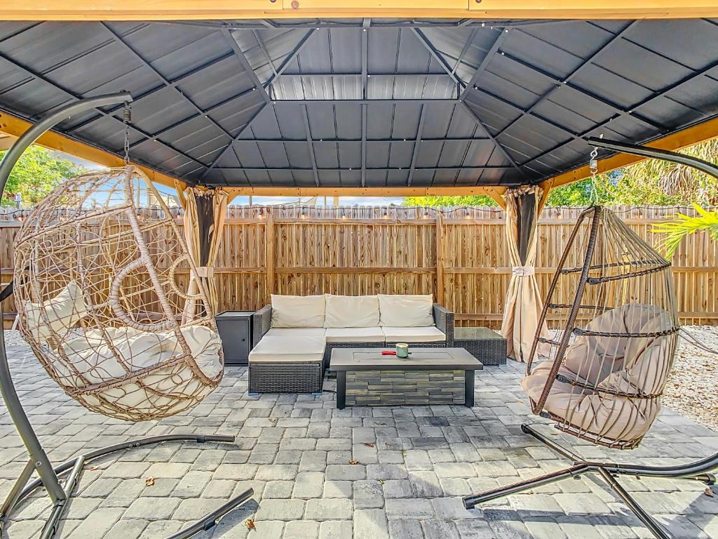 a patio with a couch and two swings at AMI, IMG, Beach, Bikes, Golf, Hottub, Fish, Beach, BBQ, SRQ in Bradenton