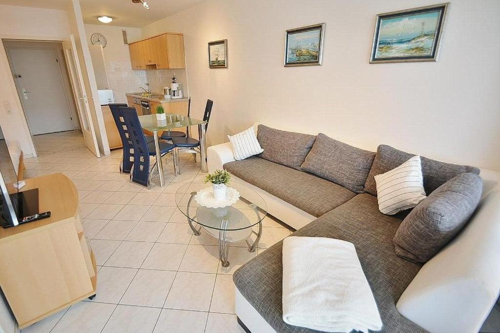 ein Wohnzimmer mit einem Sofa und einem Tisch in der Unterkunft Kaiserhof Whg 432 in Grömitz