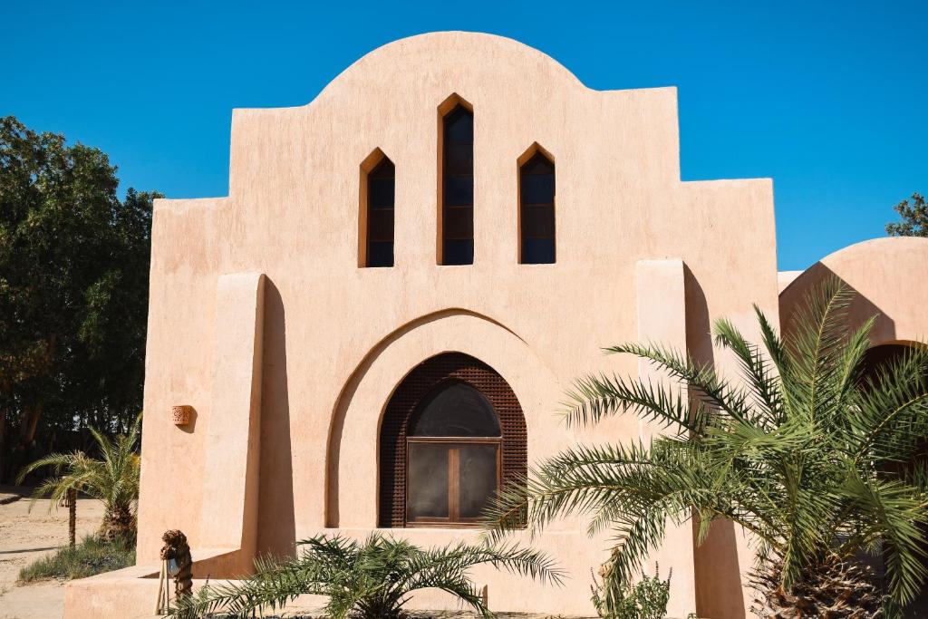 un edificio con una iglesia con una palmera en Tzila Bahariya, en Az Zaytūn