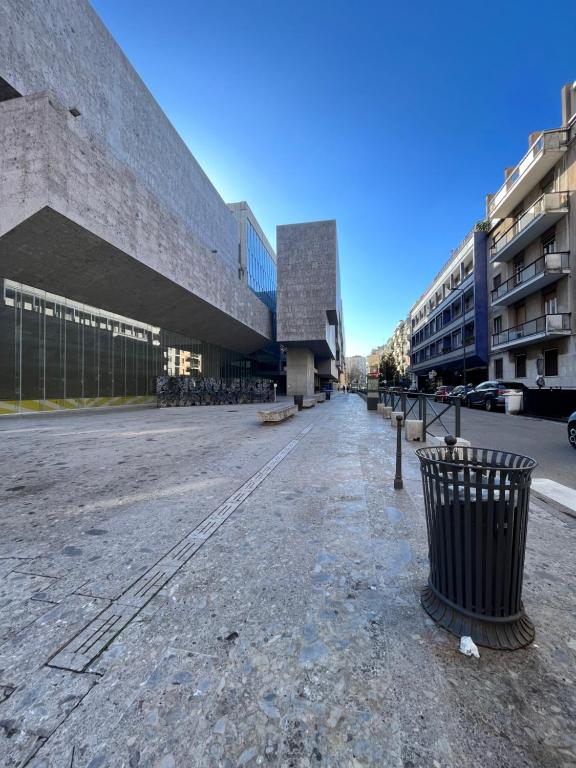 an empty street in front of a building with a trash can at Bocconi Apartment in Milan