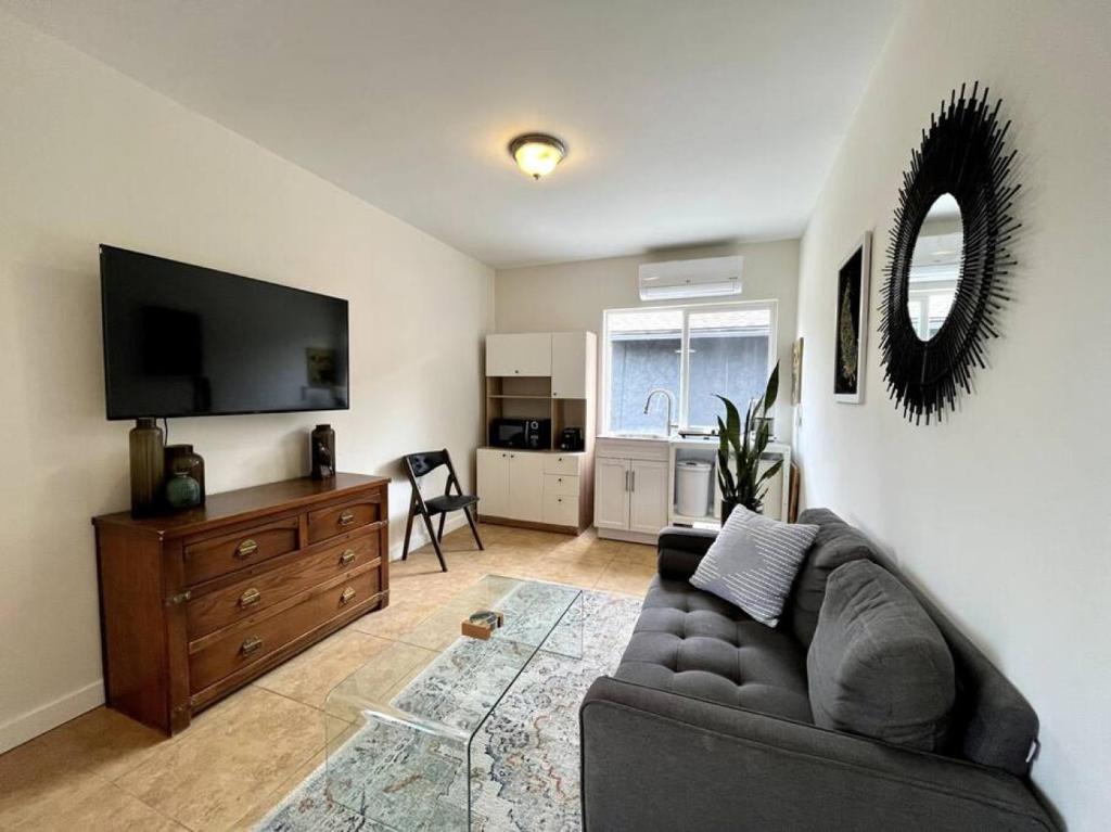 een woonkamer met een bank en een flatscreen-tv bij Serene Studio, Yurt Barn near DTLA Silverlake in Glendale