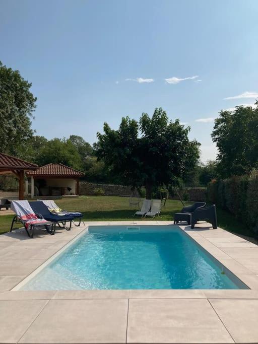 une piscine avec deux chaises et une table dans l'établissement Havre de paix proche CNPE Bugey, à Hières-sur-Amby