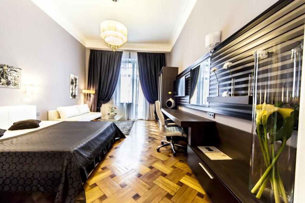 クルジュ・ナポカにあるMatei Corvin Deluxe Apartmentのベッドとデスクが備わるホテルルームです。
