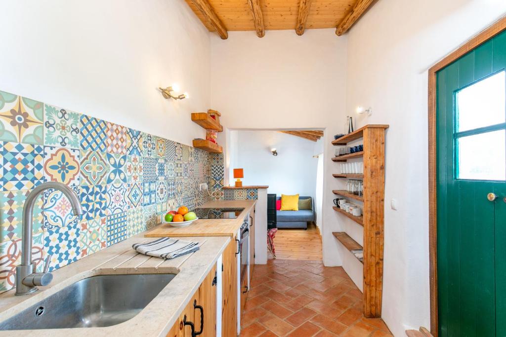 a kitchen with a sink and a green door at Da Casa Sesta in Sagres