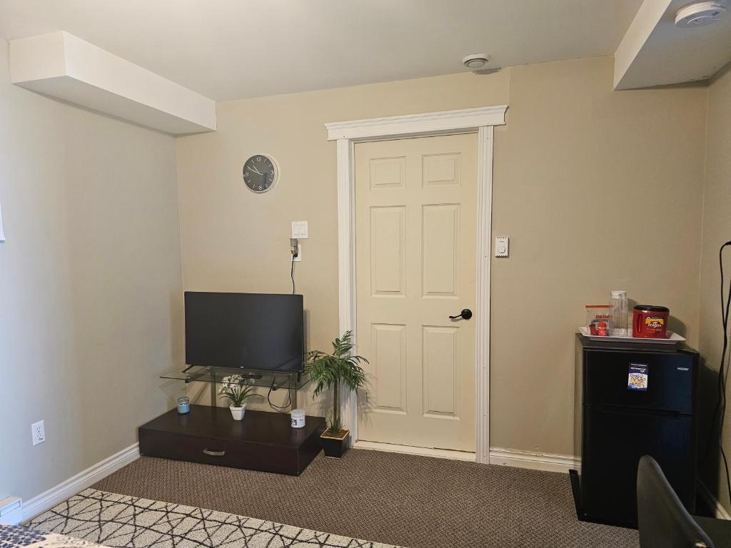 a living room with a door and a television at Quad-Ks Cozy & Private Guest Suite in Halifax