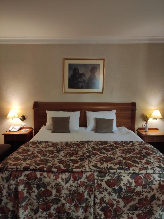 a large bed in a hotel room with two lamps at Best Western Hotel Turist - Superior in Skopje