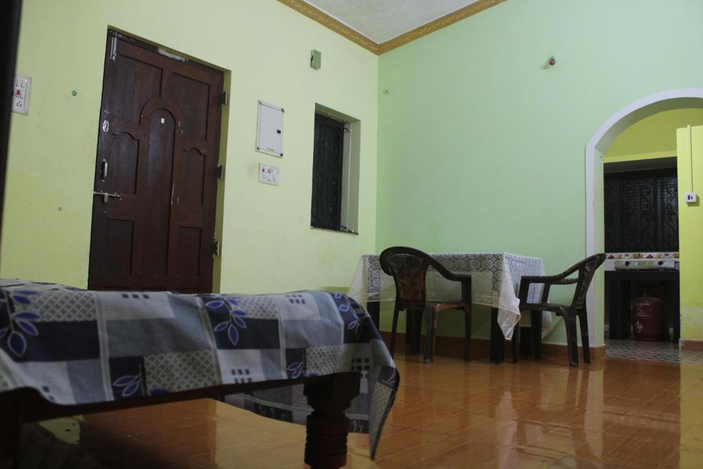 a room with a table and chairs and a door at Affordable and Cheapest stay in North Goa - 1BHK in Colovale