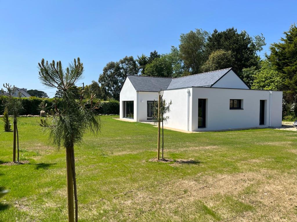 ein weißes Haus mit Bäumen im Hof in der Unterkunft Glen Ross, plage à moins de 10 min à pied in Névez