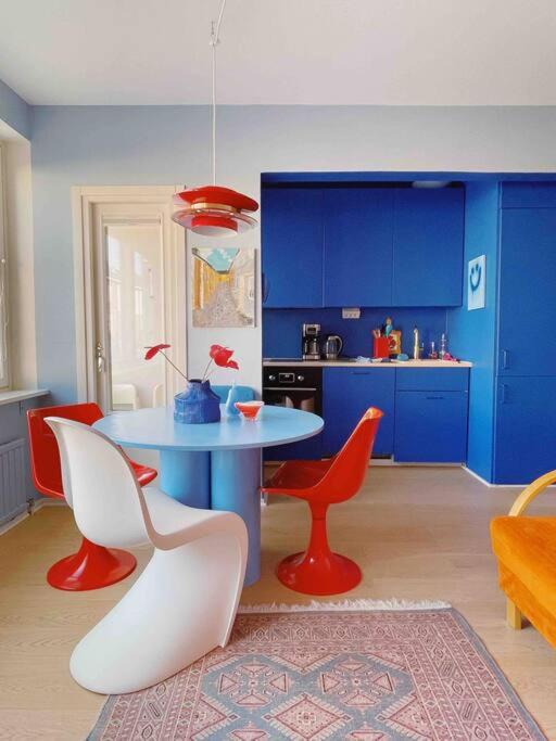 a kitchen with a table and chairs and blue cabinets at Ihana kaksio Linnanmäen vieressä in Helsinki