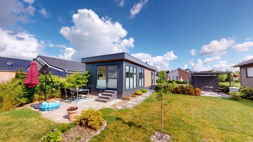 ein modernes Haus mit schwarzem Dach in der Unterkunft Haus MeerAuszeit - Erholung an der Nordsee in Schweiburg