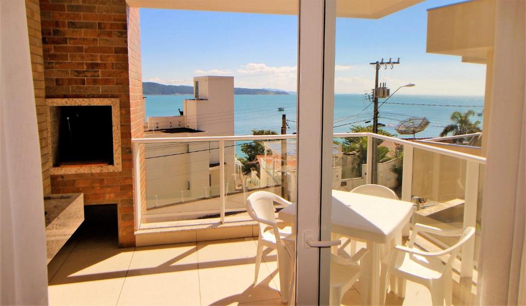 balcón con mesa y vistas al océano en 1079 - Apartamento com vista para o mar em Bombinhas, en Bombinhas