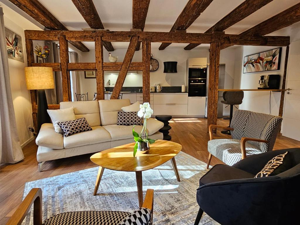 uma sala de estar com um sofá e uma mesa em Gîte Du XVe em Kaysersberg