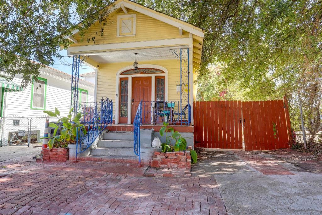 uma casa amarela com uma cerca azul em frente em New Orleans Home about 2 Mi to French Quarter! em Nova Orleans