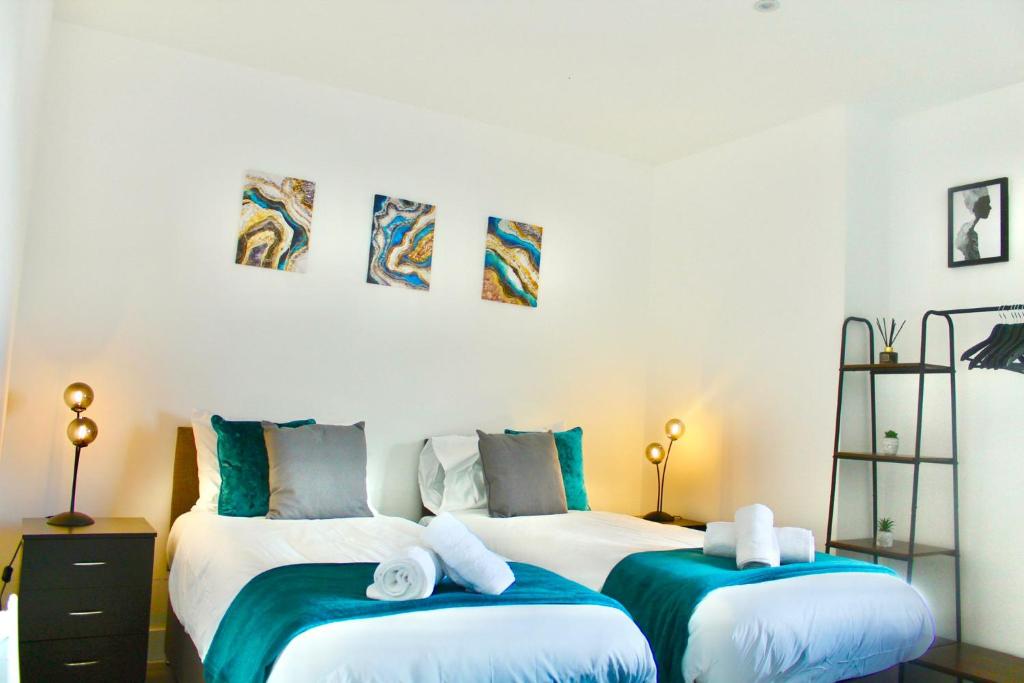 two beds in a room with blue and white at Hemel Apartments- Tranquil Haven in Hemel Hempstead