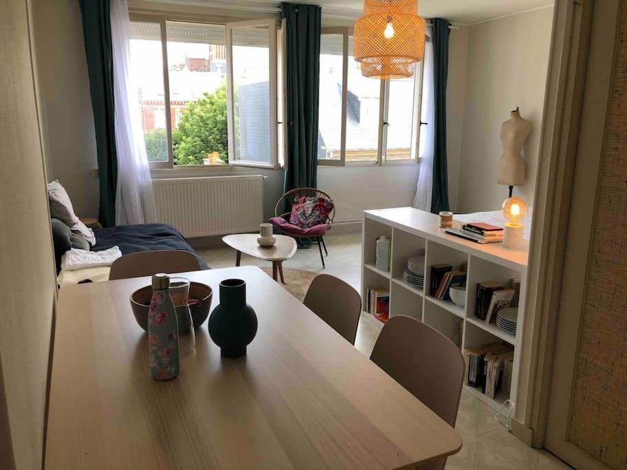a living room with a table and chairs in a room at Grand studio avec petite vue mer in Mers-les-Bains