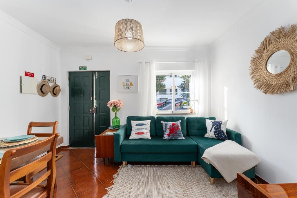 a living room with a green couch and a table at Casa Verde in Tavira
