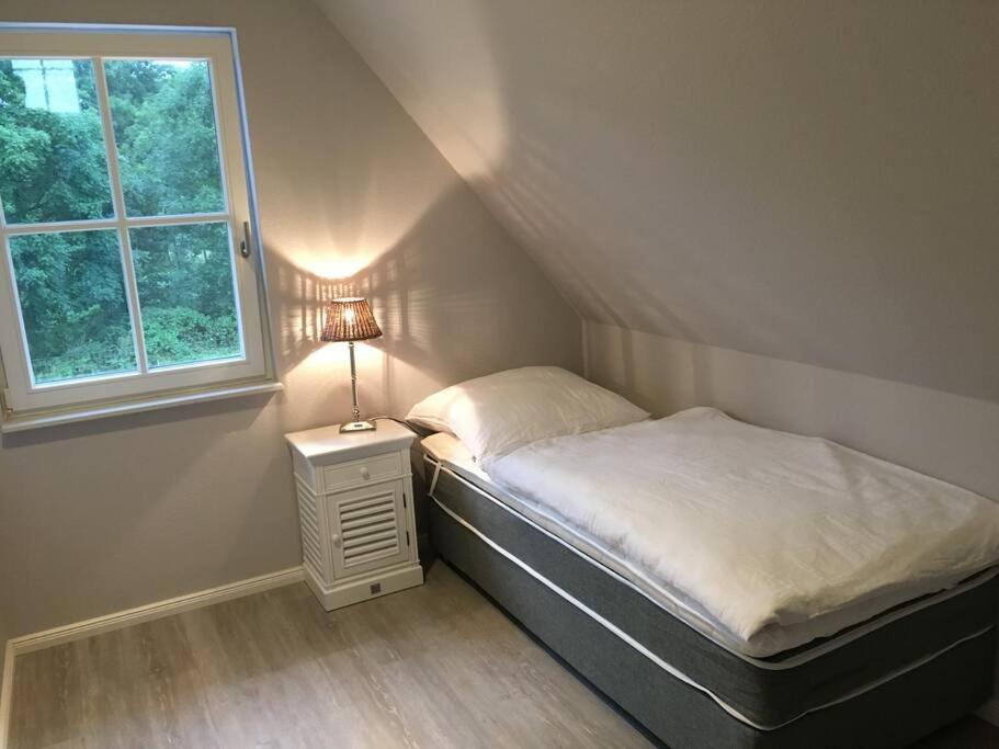 グロース・シュヴァンセにあるStilvolles Reetdachhaus Coastline an der Ostseeの窓のある部屋にある小さなベッド