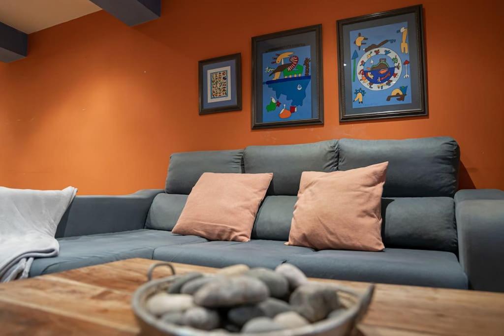 un sofá azul en una sala de estar con paredes de color naranja en Casa Grande en Casco Histórico, en Santander