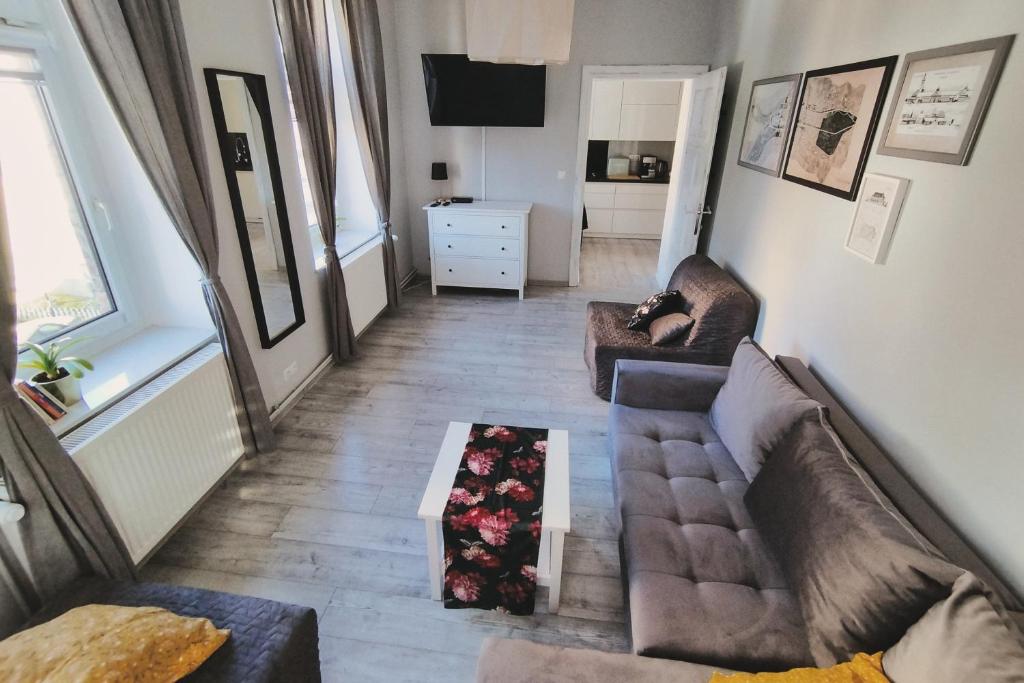 ein Wohnzimmer mit 2 Sofas und einem Tisch in der Unterkunft Kamienica Slowackiego in Duszniki-Zdrój