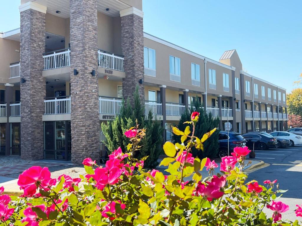 a building with pink flowers in front of it at Bposhtels Charlotte in Charlotte