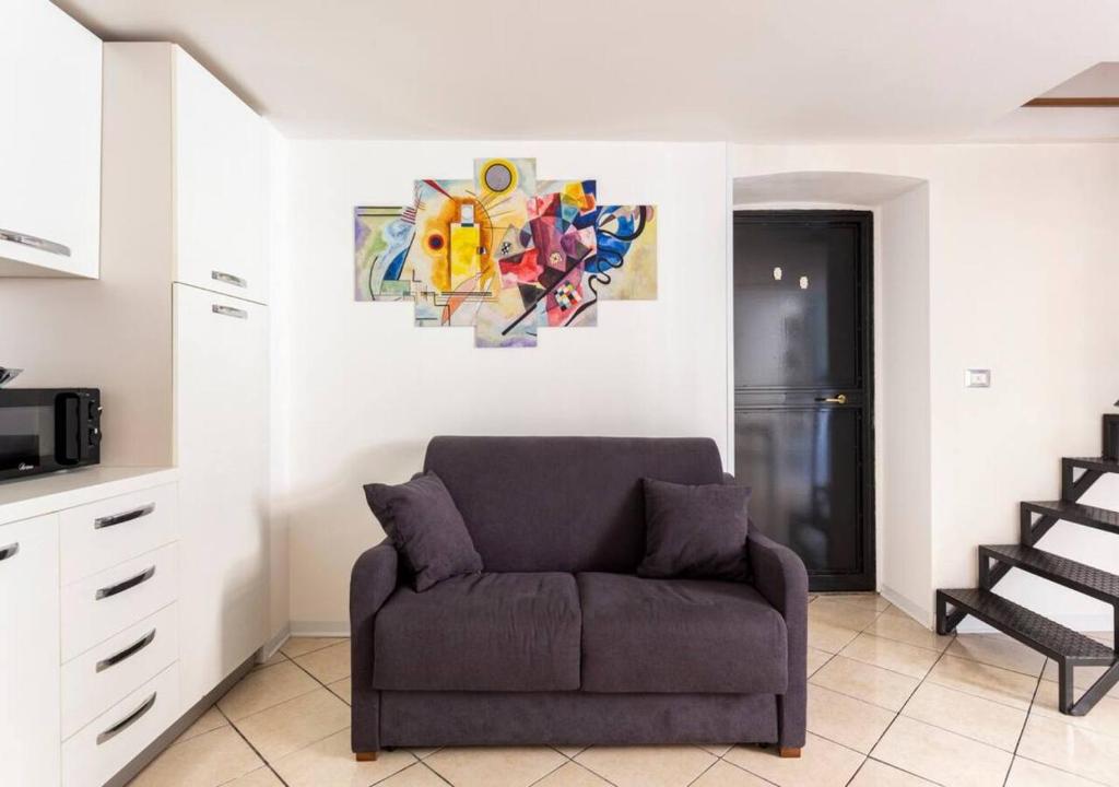 salon z kanapą i obrazem na ścianie w obiekcie Aitnè - Holiday Apartments w Katanii