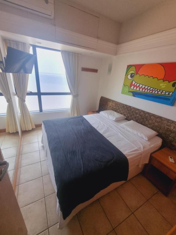 1 dormitorio con 1 cama con una pintura de dinosaurio en la pared en Tropical Executive Vista Maravilhosa, en Manaus