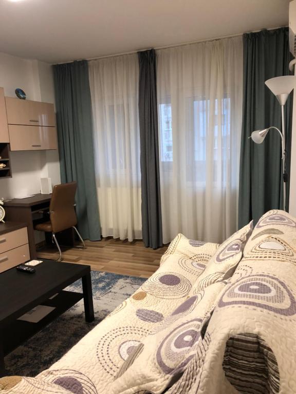 a hotel room with a bed and a desk and a desk at Adrian Home Mega in Ploieşti