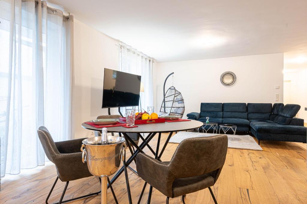 Lit Living - Luxury House - Box Spring - Parking - Exclusive Kitchen في Hemsbach: غرفة معيشة مع طاولة مع كراسي وأريكة