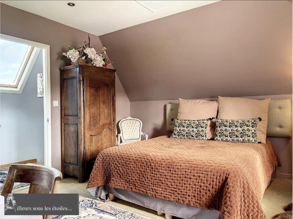 1 dormitorio con 1 cama y armario de madera en ailleurs sous les etoiles, en Manneville-la-Raoult