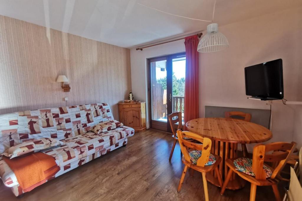 a bedroom with a bed and a table and a tv at Appartement 4 personnes au pied des pistes in Les Déserts