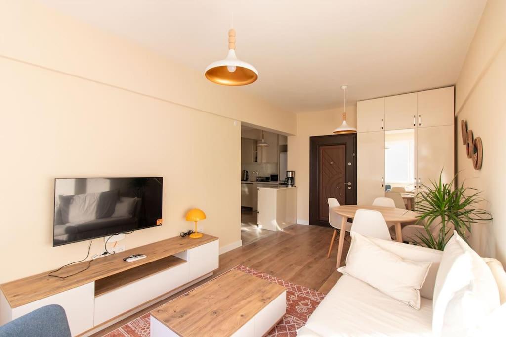 sala de estar con sofá, TV y mesa en Cozy & Complete 1BR Retreat w/ Balcony, en Estambul
