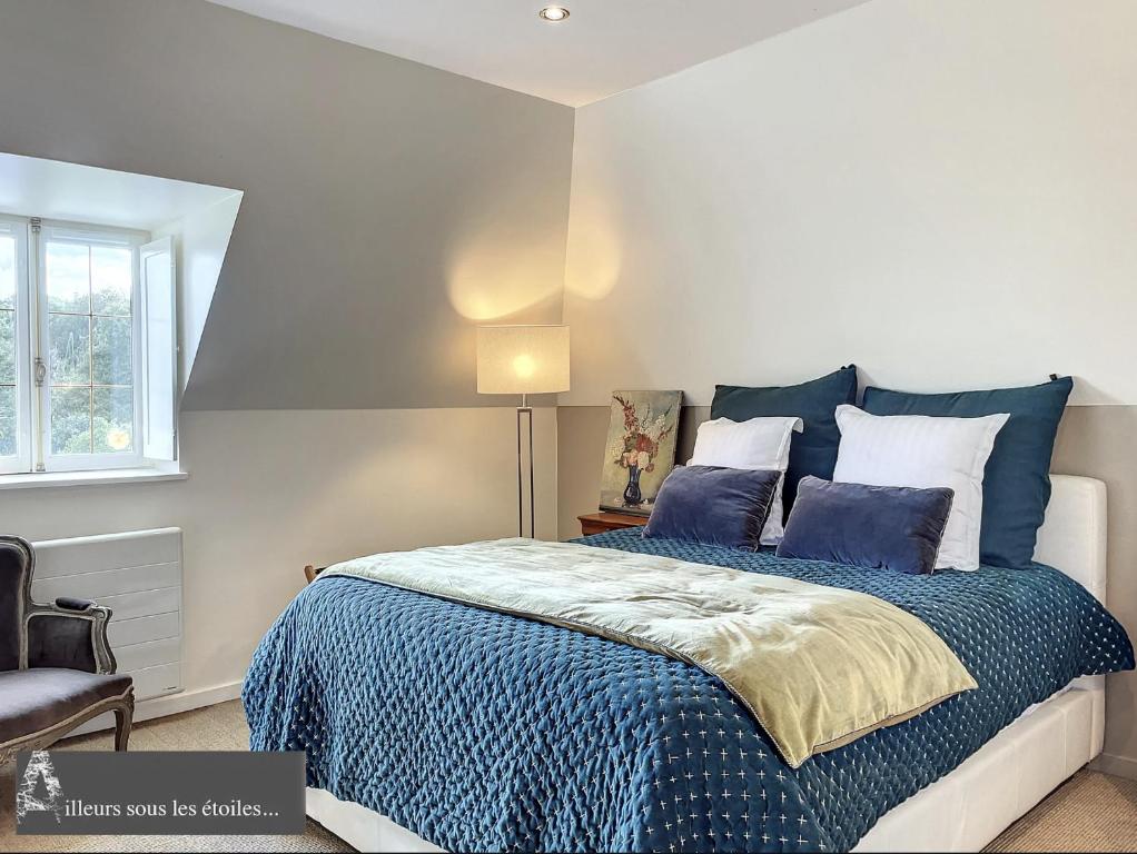 1 dormitorio con 1 cama con sábanas azules y lámpara en ailleurs sous les etoiles, en Manneville-la-Raoult