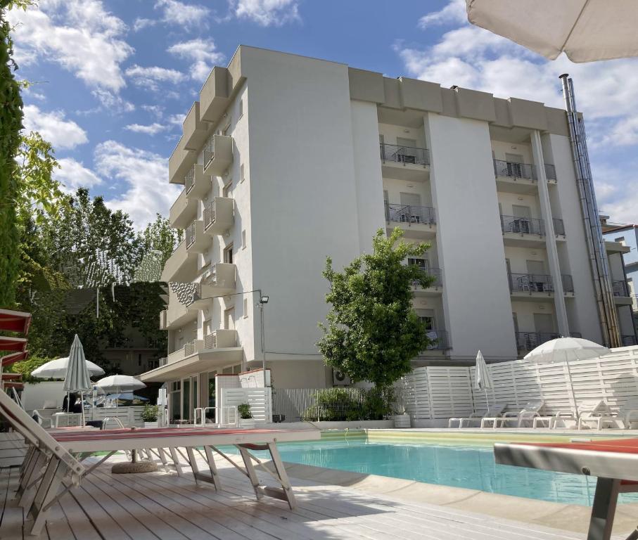 un hotel con piscina di fronte a un edificio di Hotel Villa del Parco a Rimini