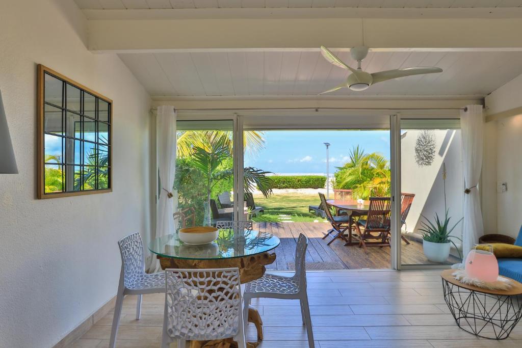 un soggiorno con tavolo e sedie e un patio di Aloe Casa - Saint-Martin Baie Nettlé - appartement sur mer a Baie Nettle