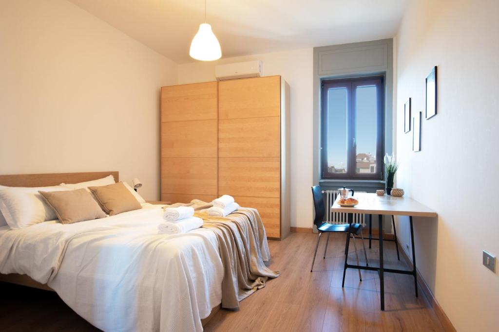 a bedroom with a bed and a table and a desk at I Host Apartment - Sant'Agostino 7 in Milan