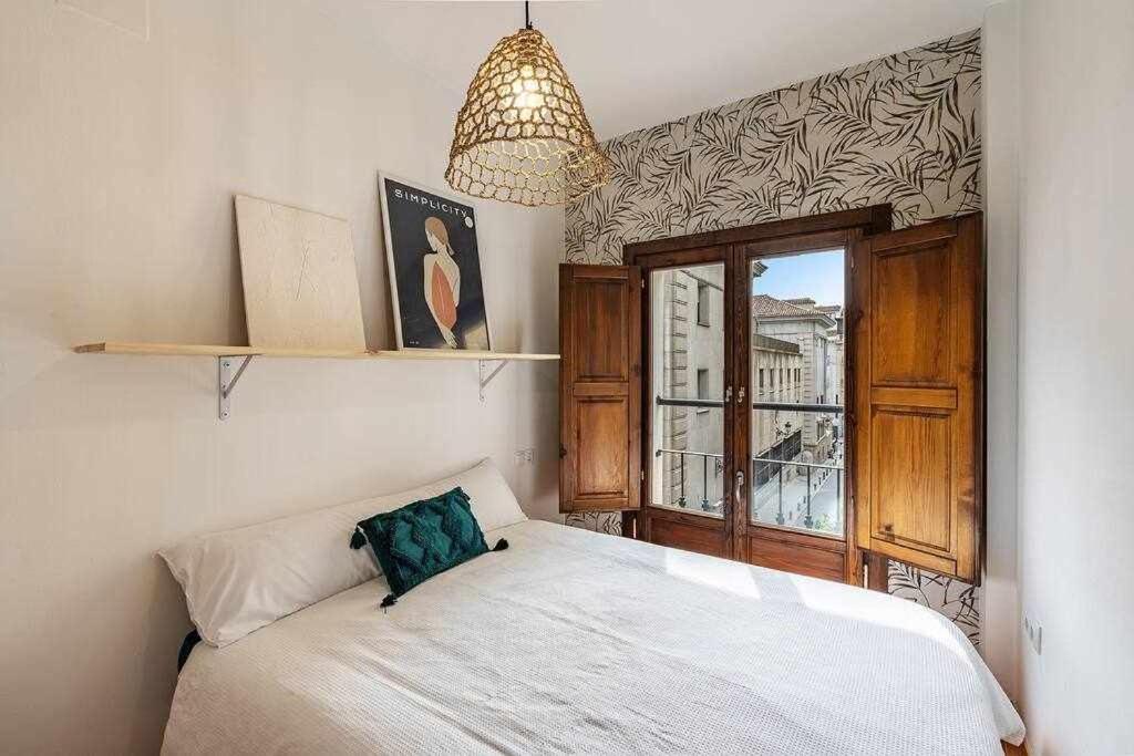 a bedroom with a white bed and a window at Alto house edificio completo in Granada