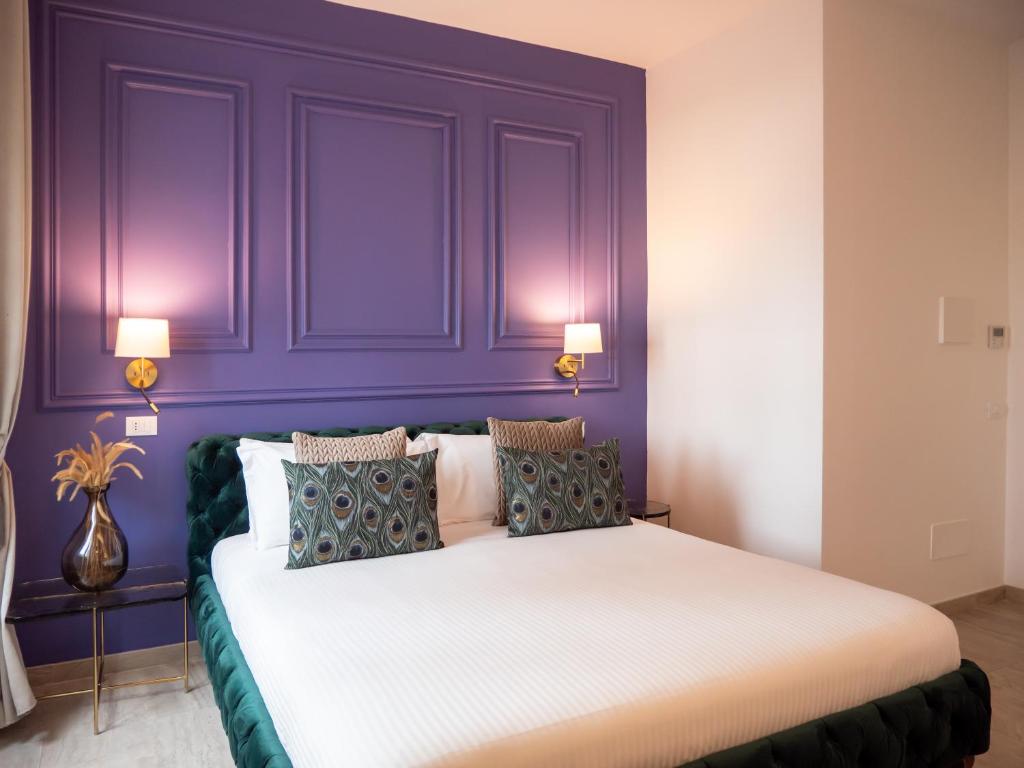 1 dormitorio con paredes moradas y 1 cama con almohadas en Alto Apartment, en Roma