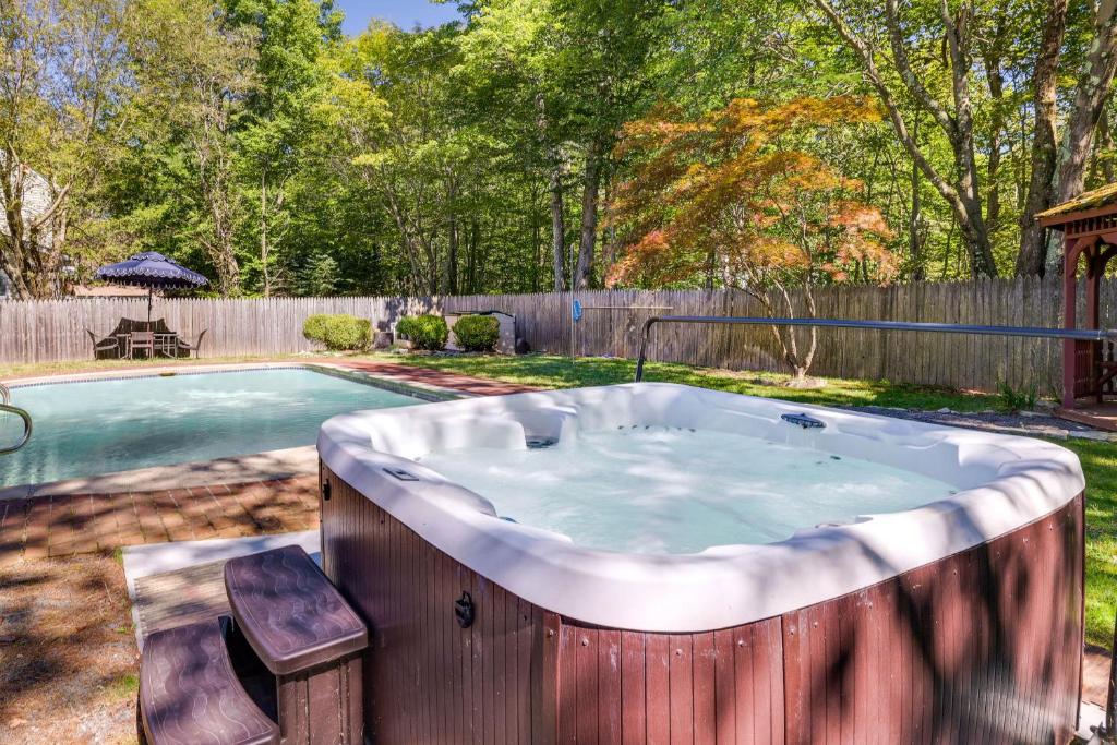 una bañera de hidromasaje en un patio junto a una piscina en Poconos Home Near Lake with Private Pool and Hot Tub!, en Tobyhanna