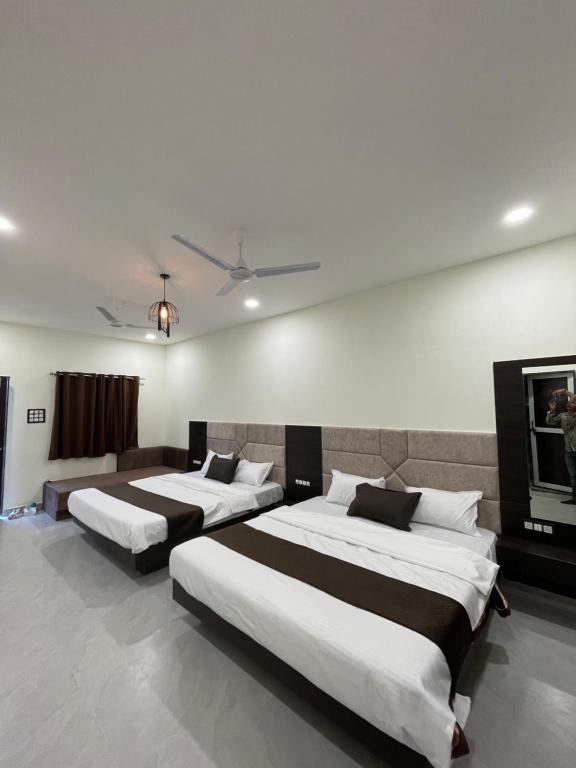 two beds in a hotel room with at Tekri Farms and Retreat in Ujjain