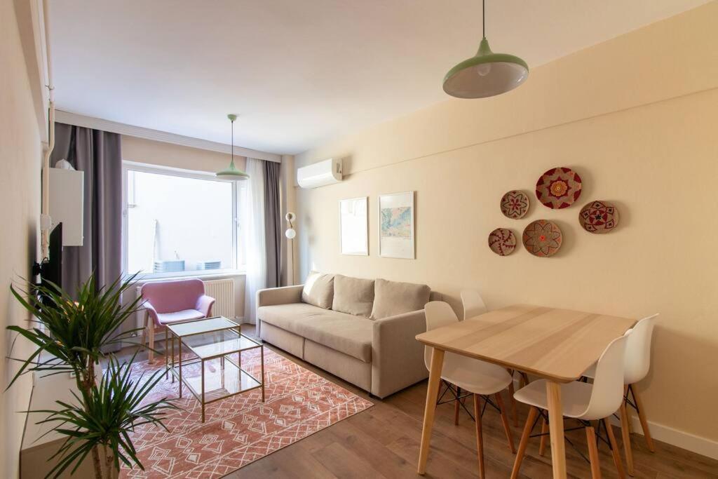 ein Wohnzimmer mit einem Sofa und einem Tisch in der Unterkunft Cosmopolitan & Stylish 1BR Apartment/Central Şişli in Istanbul