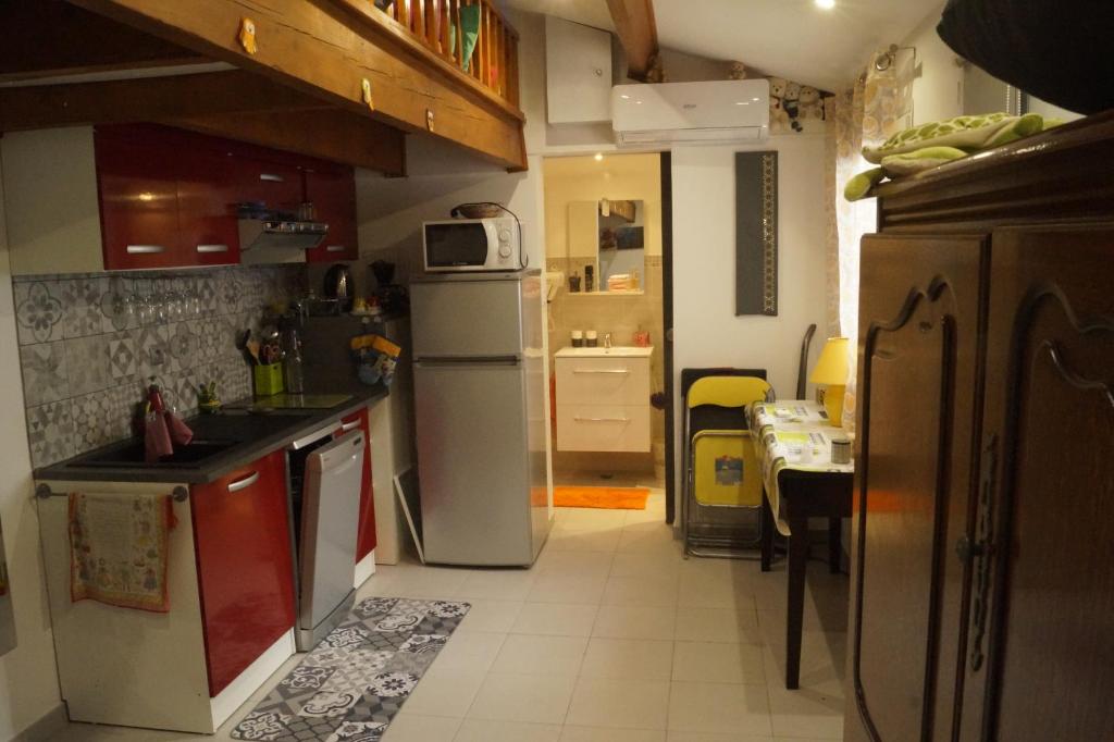 cocina con fregadero, nevera y mesa en Hébergement indépendant dans villa privée avec piscine, en Le Rove