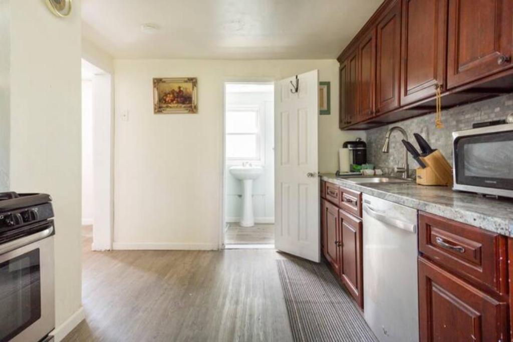 een keuken met houten kasten en een wastafel bij cozy room with private bathroom in Arlington