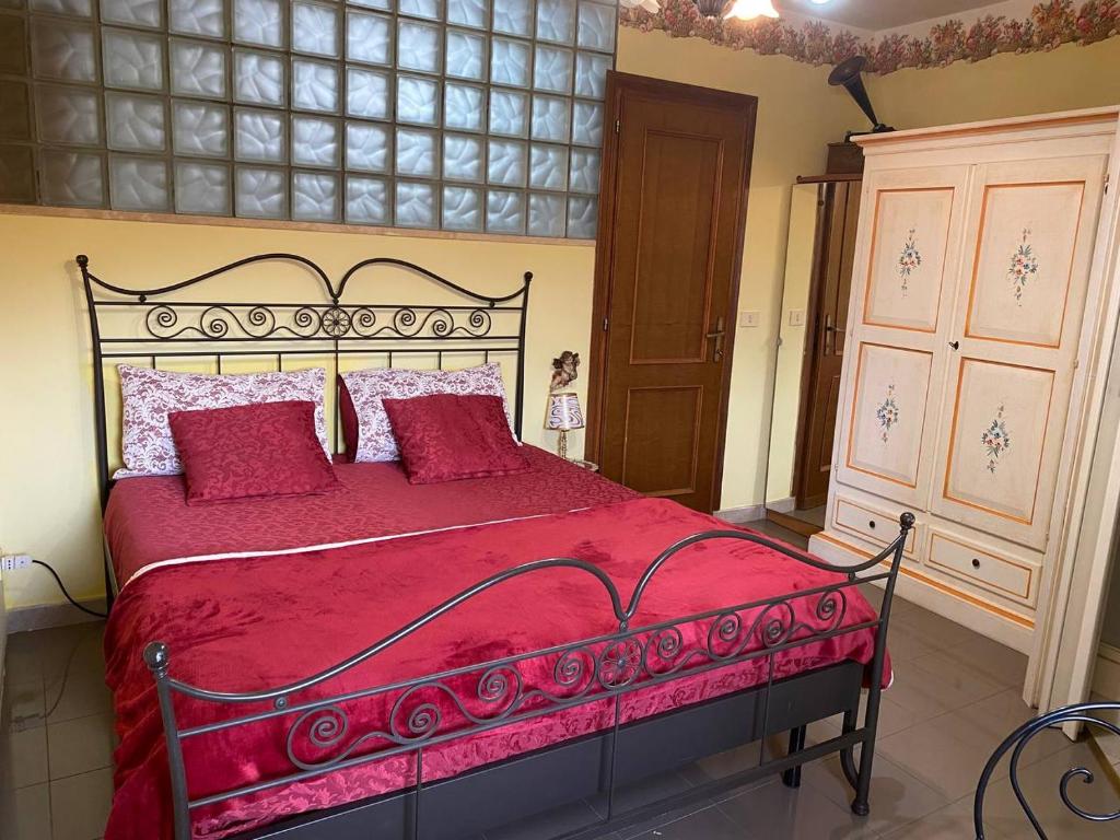 - une chambre avec un grand lit rouge et des oreillers rouges dans l'établissement Casa vacanze Il Geranio, à Celleno