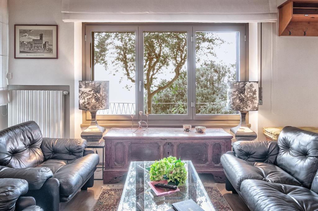 salon z kanapami, stołem i oknem w obiekcie Maya Luxury Home - Together in Tuscany w mieście Cortona
