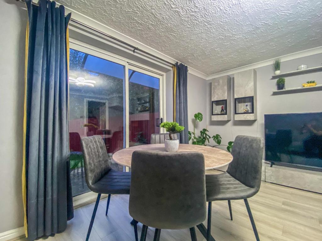 a dining room with a table and chairs and a window at 3 Bedroom House by Elegance Living in Peterborough