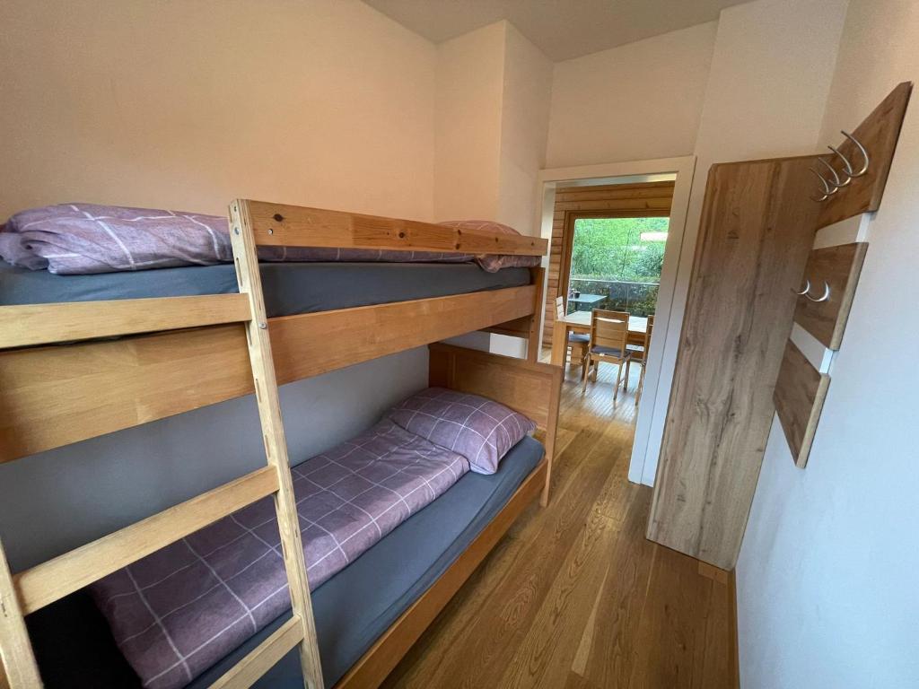 a bedroom with bunk beds and a dining room at Camping Hierhold in Kumberg