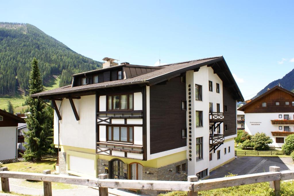 una casa en las montañas con una valla de madera en Haus Schuschnig, en Bad Kleinkirchheim
